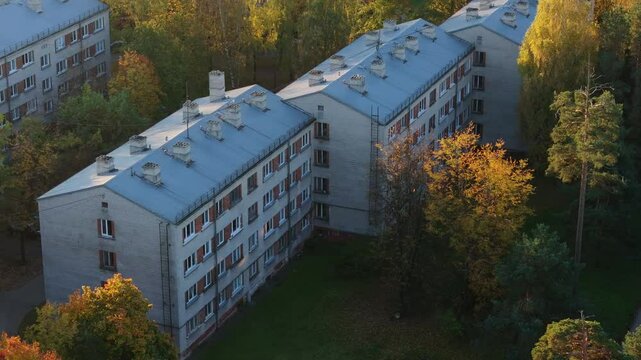 Khrushchyovka building at autumn sunrise with a seagull flying into the frame.