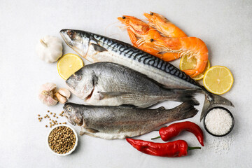 Different fresh sea food with spices on light grey table, flat lay