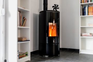 Pellet stove in a living room with bookcase and heat diffuser