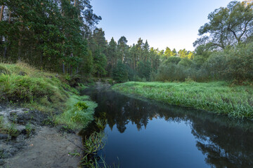 A calm river with trees in the background
