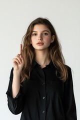 Obraz premium A woman holds up her index finger in a gesture of pointing or emphasis