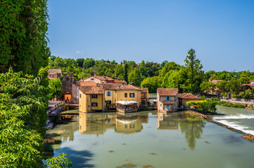 Obraz premium Summer on the Mincio river. Historic village of Borghetto sul Mincio
