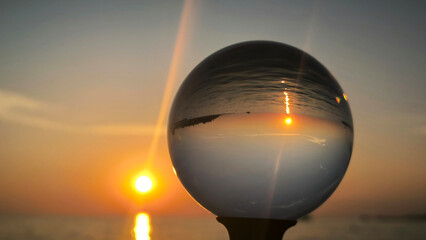 sunset by the Adriatic sea in Porec, seen through the glass lensball