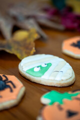 
Homemade Halloween-themed desserts. Various cakes containing the faces of different monsters of the Halloween holiday. Background containing autumn leaves.