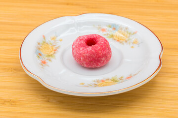 Plate with a panellet on a wooden surface. Panellets are traditional sweets for All Saints' Day in Catalonia, the Balearic Islands, Levante and Aragon.