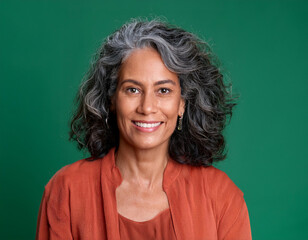 Fototapeta premium Studio Portrait of Mature Teacher Woman Happily Smiling Against Colored Studio Background