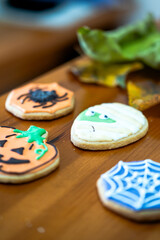 
Homemade Halloween-themed desserts. Various cakes containing the faces of different monsters of the Halloween holiday. Background containing autumn leaves.