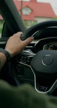 A man drives a car. Close-up of his hands on the steering wheel, an unrecognizable person. View from the car interior. Summer day