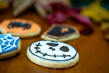 
Homemade Halloween-themed desserts. Various cakes containing the faces of different monsters of the Halloween holiday. Background containing autumn leaves.