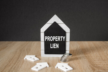 Concept words Property Lien on black blackboard. Beautiful wooden table, black background. A stack...