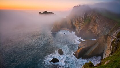 Fog covering dramatic coastline at sunset