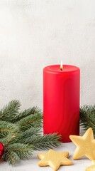 A festive red candle surrounded by pine branches and golden star-shaped cookies on a rustic wooden table