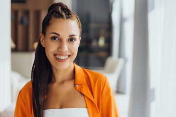 Portrait of beautiful, smiling Latin woman with braces, looking at camera posing at home