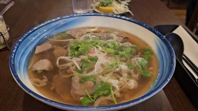 Steaming bowl of hot Vietnamese beef noodles (Pho Dac Biet)