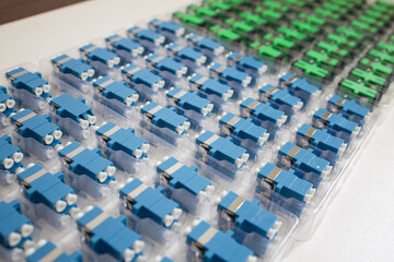 Obraz premium Optical adapters with different connectors in plastic blisters on the table, a batch of goods 