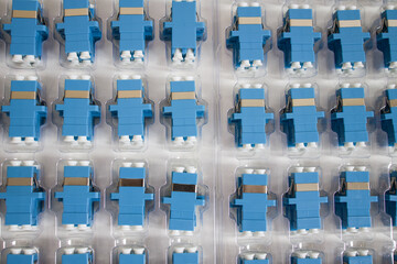 Obraz premium Optical adapters with different connectors in plastic blisters on the table, a batch of goods 