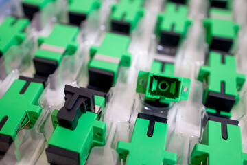 Optical adapters with different connectors in plastic blisters on the table, a batch of goods	
