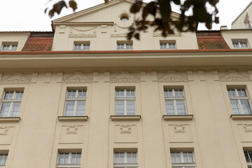 There is a large and impressive building that features numerous windows, along with a striking red roof that enhances its overall aesthetic appeal