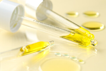 Cosmetic oil and pipettes on dark beige background, closeup