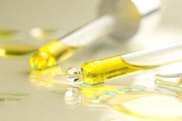 Cosmetic oil and pipettes on dark beige background, closeup