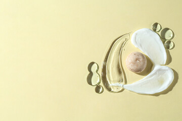 Smears of different cosmetic products on beige background, top view. Space for text