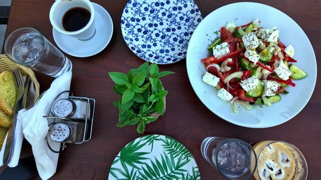 Table served with coffee, bread and delicious Greek salad with fresh vegetables and feta cheese in restaurant located in Sivas, Greece