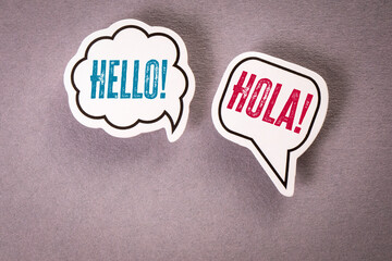 Hello in English and Spanish. Two speech bubbles on a gray background
