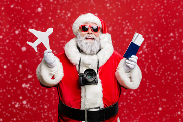 Portrait of funny hipster santa claus have journey abroad in terminal want travel take photo photigraphing wear spectacles eyewear eyeglasses costume isolated over red background