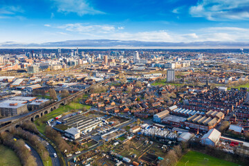 Obraz premium Aerial photo of the town of Hunslet in Leeds West Yorkshire in the UK, showing roads and rows of residential houses taken in the winter time with the Leeds city centre in the background