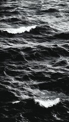 Naklejka premium Black and white image of ocean waves crashing, creating a dramatic and moody scene.