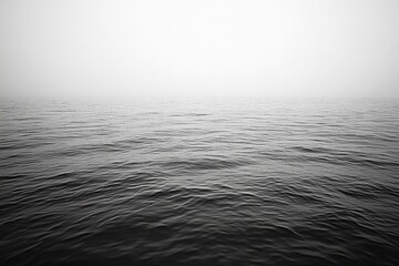 A tranquil scene of the ocean on a foggy day.