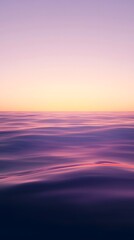 Obraz premium A calm sea at sunset, with the horizon blending into a gradient of purples and oranges, creates an atmosphere that feels serene and peaceful.