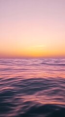 Obraz premium A calm sea at sunset, with the horizon blending into a gradient of purples and oranges, creates an atmosphere that feels serene and peaceful.