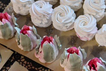 Homemade marshmallows are spread out on the table surface. They are setting and stabilizing before packaging. The marshmallows are classic. Marshmallow tulips.