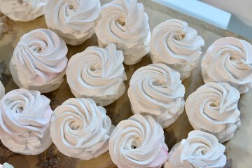 Homemade marshmallows are spread out on the table surface. They are setting and stabilizing before packaging.