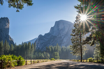 A striking view of Half Dome, in Yosemite Valley National Park, as the sun crests the huge monolith. A multi pointed sun star is created.