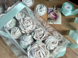 Marshmallow flowers in a gift box with a transparent lid. A card with the inscription in Russian Endless happiness.