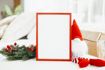 Fototapeta premium Cozy holiday setting with a blank frame and festive decorations on a table