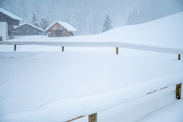 Fototapeta premium While it snows. Under a heavy snowfall walking in the village of Cima Sappada