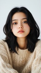 ライフスタイルとファッションメディア向けの、心地よいセーターを着た若い女性のポートレート