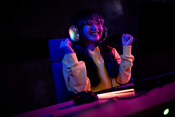 Photo of gamer lovely young lady winning raise fists play strategy game gamer laptop late night room indoors