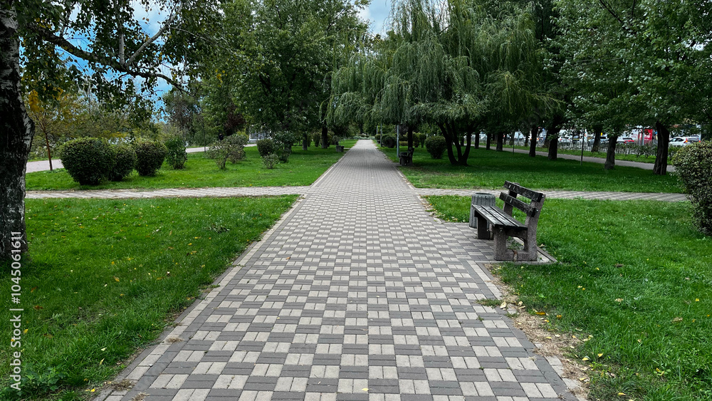 Aufkleber a park with a path and a bench. the path is made of bricks and the bench is made of wood