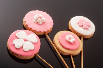 Baby cookies decorated with glaze on a black background. Baby girl.