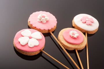 Baby cookies decorated with glaze on a black background. Baby girl.