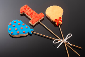 Baby cookies decorated with glaze on a black background. Baby boy.