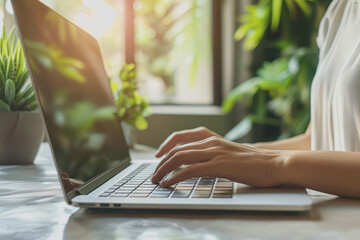 Asian casual businessman typing on a laptop computer working from home.