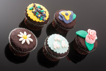 Tasty colorful cupcakes on blackbackground
