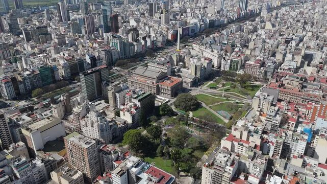 Amazing birdseye view of the Obelisc and the park and cityscape around in Buenos Aires, pan shot, sunny daylight