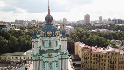 Ukraine, Kyiv's famous St.Andrew Church's drone footage on a summer day with cloudy skies. Footage zooms out and turns around the church from a perfect angle, streets around the church also visible.