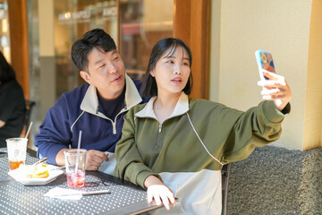 A couple, a Korean man in his 30s and a woman in her 20s, wear tracksuits and enjoy an afternoon at...